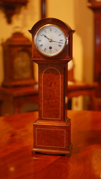 This has to be seen to fully appreciate the small proportions and the superb detail in the construction of the case . A miniature longcase or 'Grandfather' clock that stands only 44.3 cms tall ( about 17 and a Half inches ). It has an engraved and silvered dial showing roman numerals , a brass bezel and bevelled glass . The case is veneered in a beautiful burr Elm with box wood line inlay and standing on taditional style bracket feet , the rear door opens to give access to the movement which is has jewelled lever escapement  , and the clock is wound through the dial , stamped Coventry . circa 1950 . 