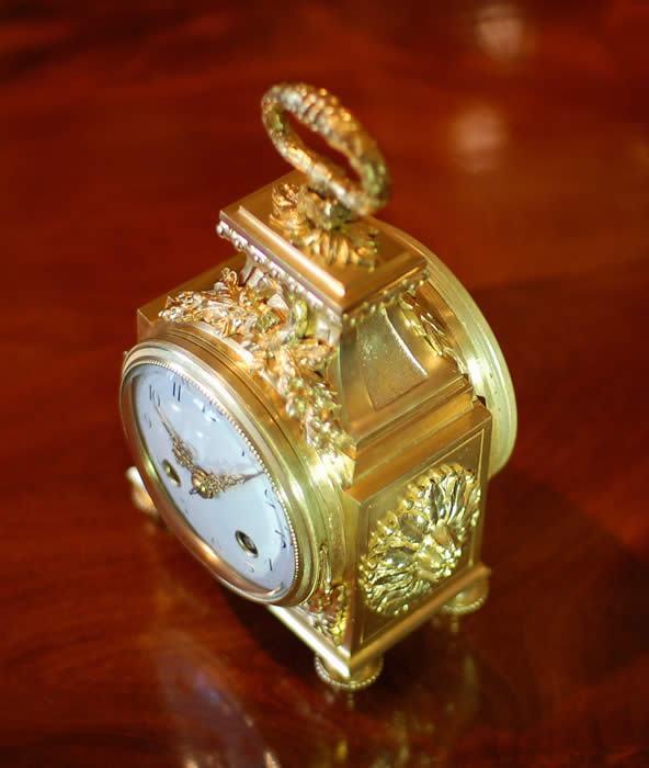 A fine Pendule d'officier with 8 day duration movement with a jeweled lever escapement . The convex enamelled dial showing black Arabic numerals with minutes to the outer edge and gilt quarter markers , decorated with finely chased , pierced and gilded hands . The case having floral and ribbon gilt mounts in the classic 'Pagoda' shape . The drop handle with vine leaves and grapes . Standing on four turned feet . Circa 1890. 