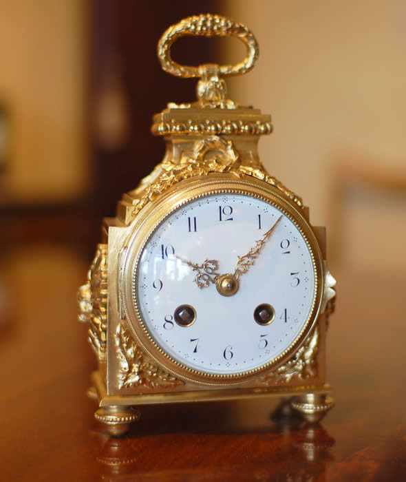 A fine Pendule d'officier with 8 day duration movement with a jeweled lever escapement . The convex enamelled dial showing black Arabic numerals with minutes to the outer edge and gilt quarter markers , decorated with finely chased , pierced and gilded hands . The case having floral and ribbon gilt mounts in the classic 'Pagoda' shape . The drop handle with vine leaves and grapes . Standing on four turned feet . Circa 1890. 