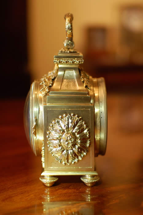 A fine Pendule d'officier with 8 day duration movement with a jeweled lever escapement . The convex enamelled dial showing black Arabic numerals with minutes to the outer edge and gilt quarter markers , decorated with finely chased , pierced and gilded hands . The case having floral and ribbon gilt mounts in the classic 'Pagoda' shape . The drop handle with vine leaves and grapes . Standing on four turned feet . Circa 1890. 