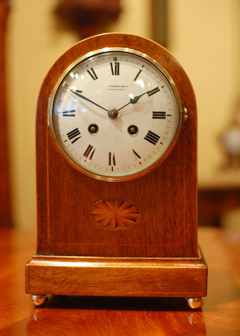 A French 8 Day , mantel clock, striking the hours and the half hours on a gong , White enamel dial with arabic numerals , the case in mahogany with inlays and brass handles , Brass rear door with sound fret and silk, Dial signed 'Perry and Co ' of Birmingham who would have been the retailer of the clock (see close up pictures) . Circa 1870-80